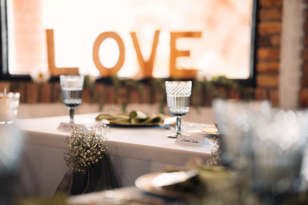 Detalle horizontal de mesa de recepción, copas y rótulo LOVE