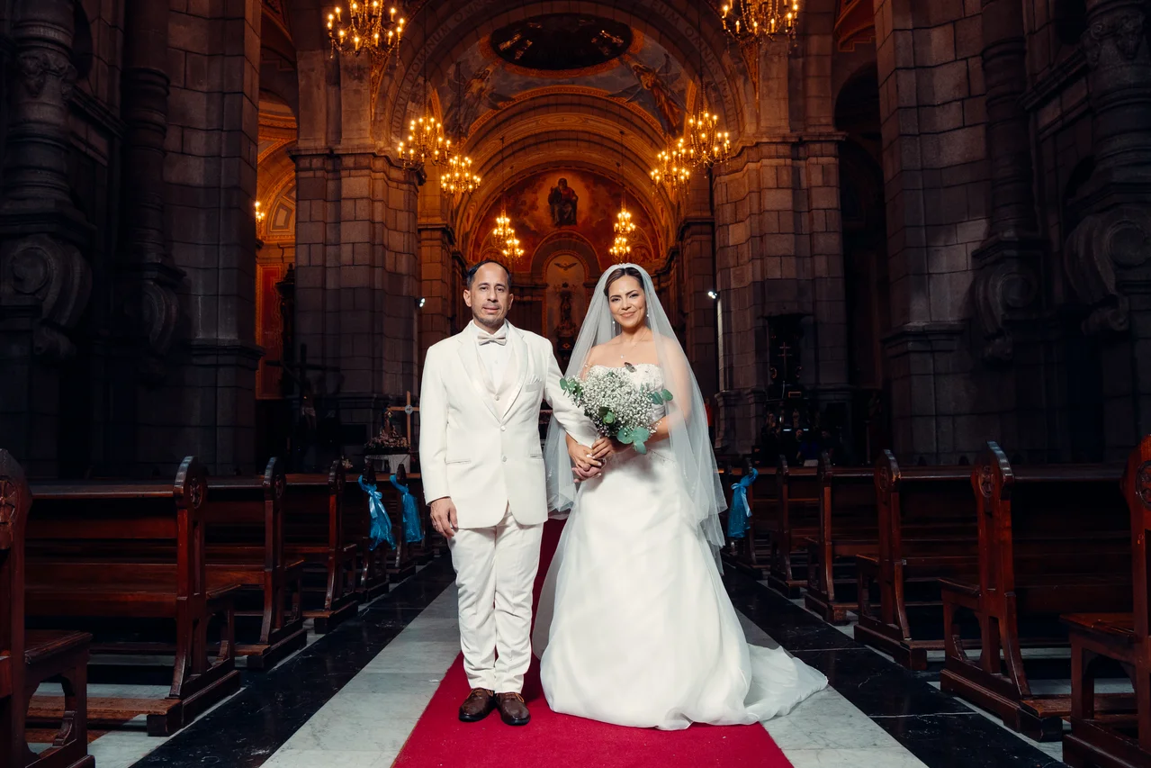Pareja en pasillo de iglesia entre columnas, arcos y luces doradas
