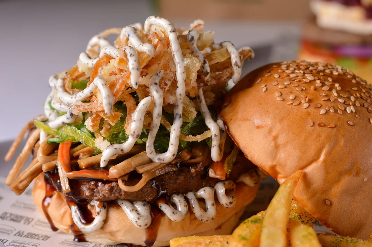 Plano cercano de hamburguesa con textura, salsa y capas visibles