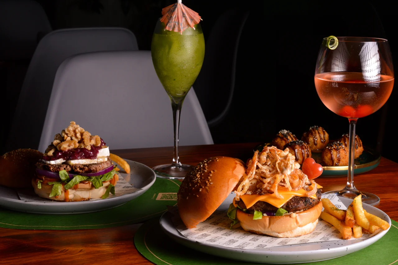 Composición horizontal de hamburguesas y bebidas con iluminación lateral cálida