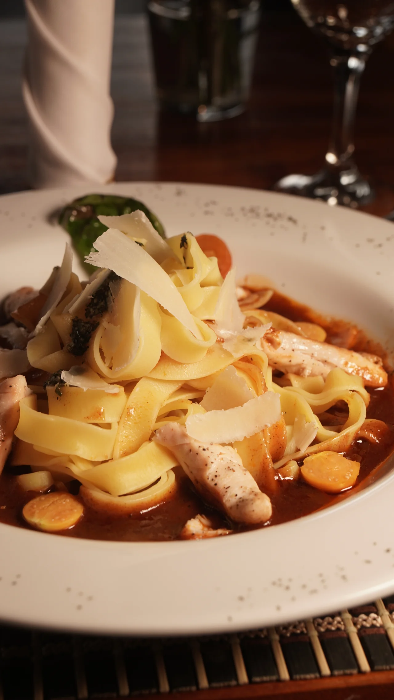 Detalle de pasta con láminas de queso y salsa