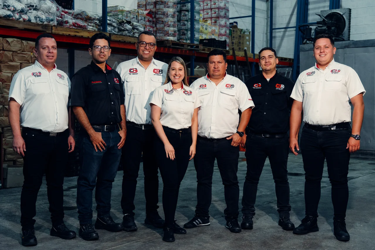 Equipo de siete colaboradores uniformados dentro del almacén