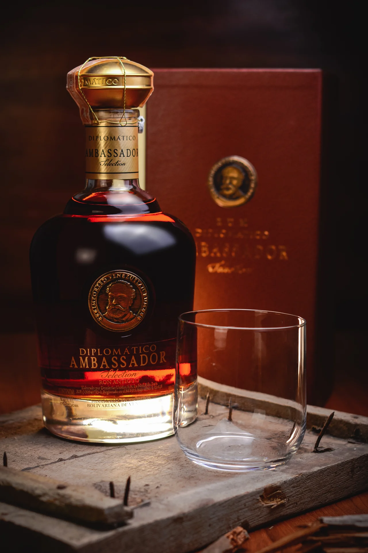 Botella de ron Diplomático y vaso sobre madera envejecida
