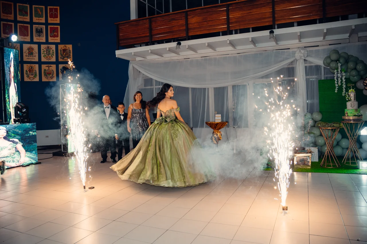 Entrada de quince años con chispas y humo en plano amplio