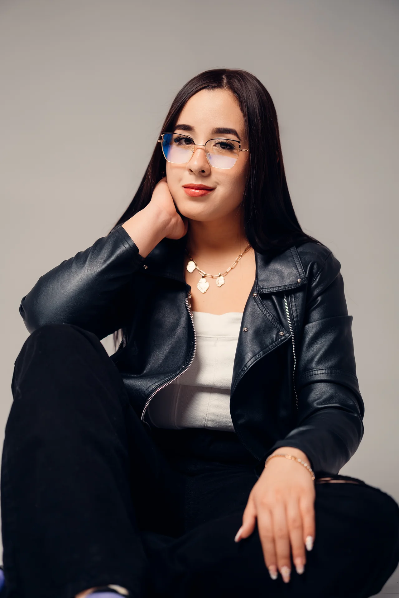 Retrato sentado con chaqueta negra y mano junto al cuello